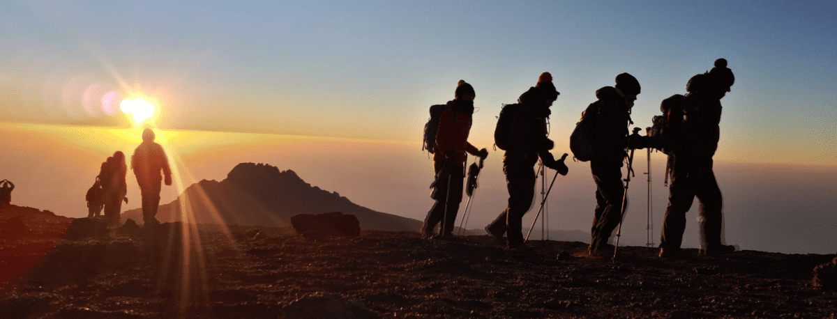 silhoutte of a group of climbers in mt. kilimanjaro