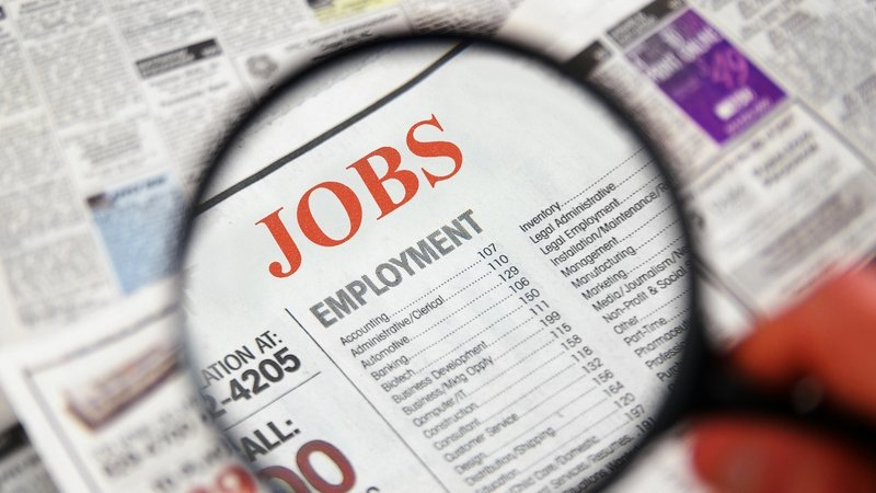 magnifying lens over Jobs page on a newspaper