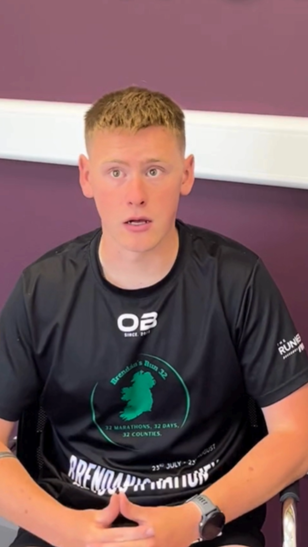 Brendan O'Neillspeaks to camera. They are sitting in front of a purple background